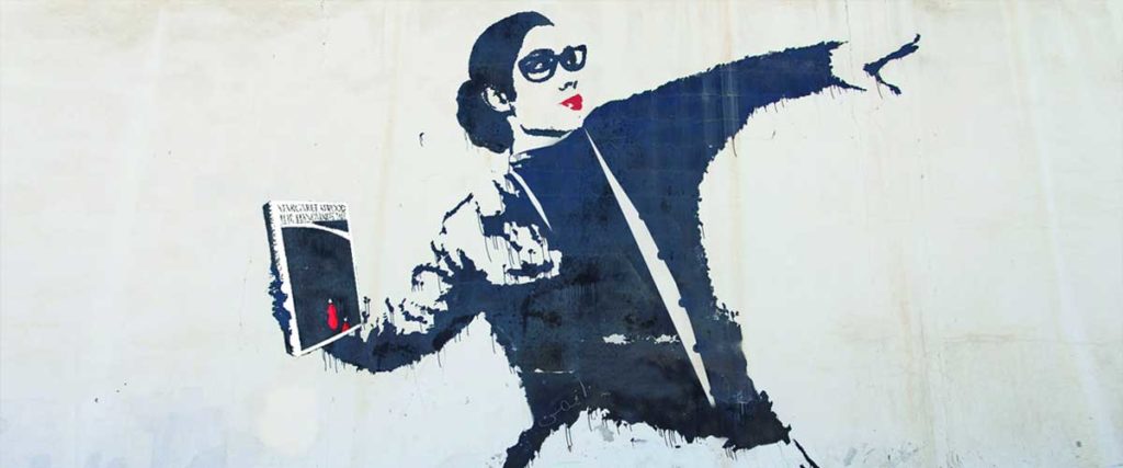 Banksy art showing a woman throwing an Atwood book like a weapon.