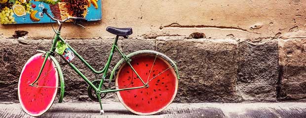A green bicycle with wheels that look like slices of watermelon.